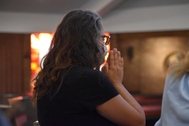 A teacher prays during the back to school Mass