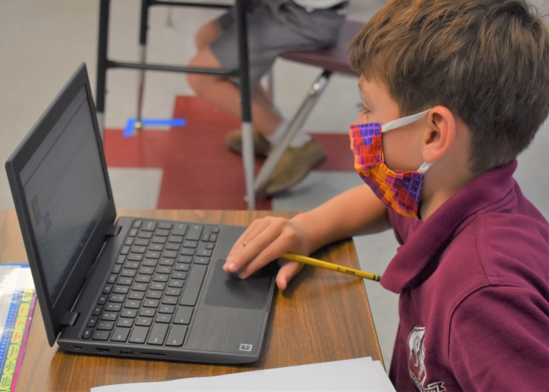 3rd grade student works on a Chromebook laptop