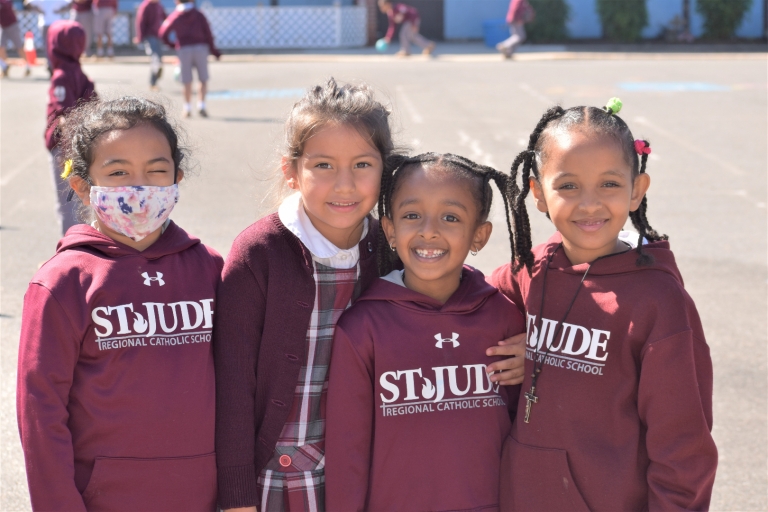 Four girls smile at recess